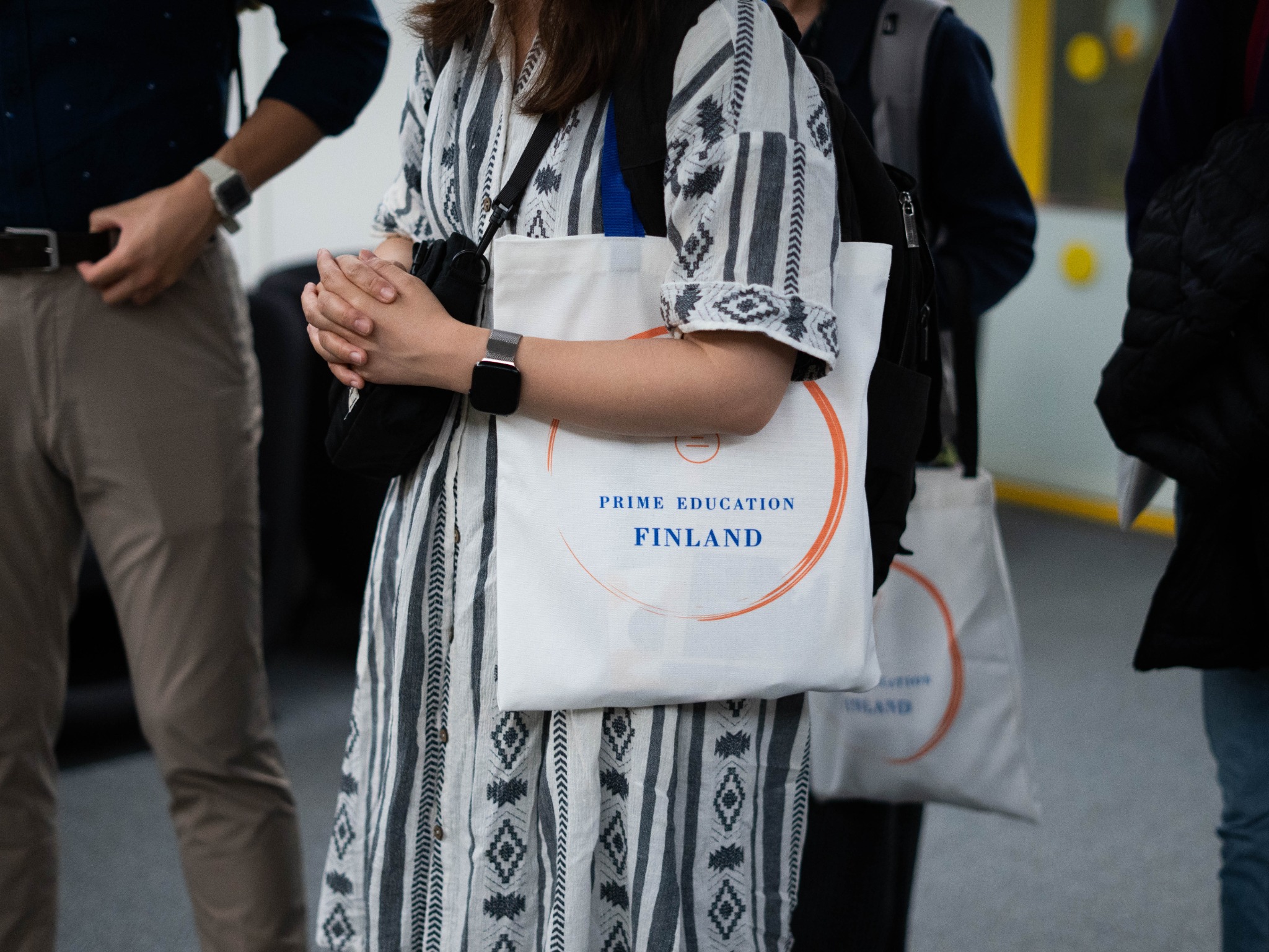 A participant carrying a Prime Education Finland programme bag